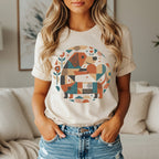 Cream t-shirt with abstract geometric dog design and floral accents.
