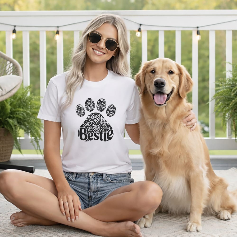 Woman in white t-shirt with "Bestie" paw print and golden retriever.