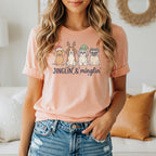 Peach t-shirt with four dogs in Christmas hats and text "JINGLIN' & mingling'".