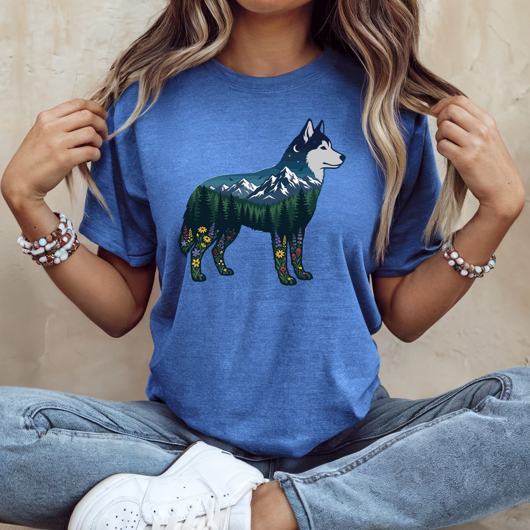 Blue t-shirt with husky silhouette filled with mountain, forest, and floral landscape.