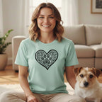 Woman wearing a mint green t-shirt with a black heart and paw print design.
