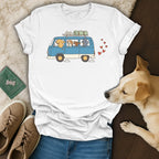White t-shirt with cartoon dogs in a blue van and red hearts graphic.