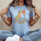 Light blue t-shirt with a colorful dog sniffing a flower and text.