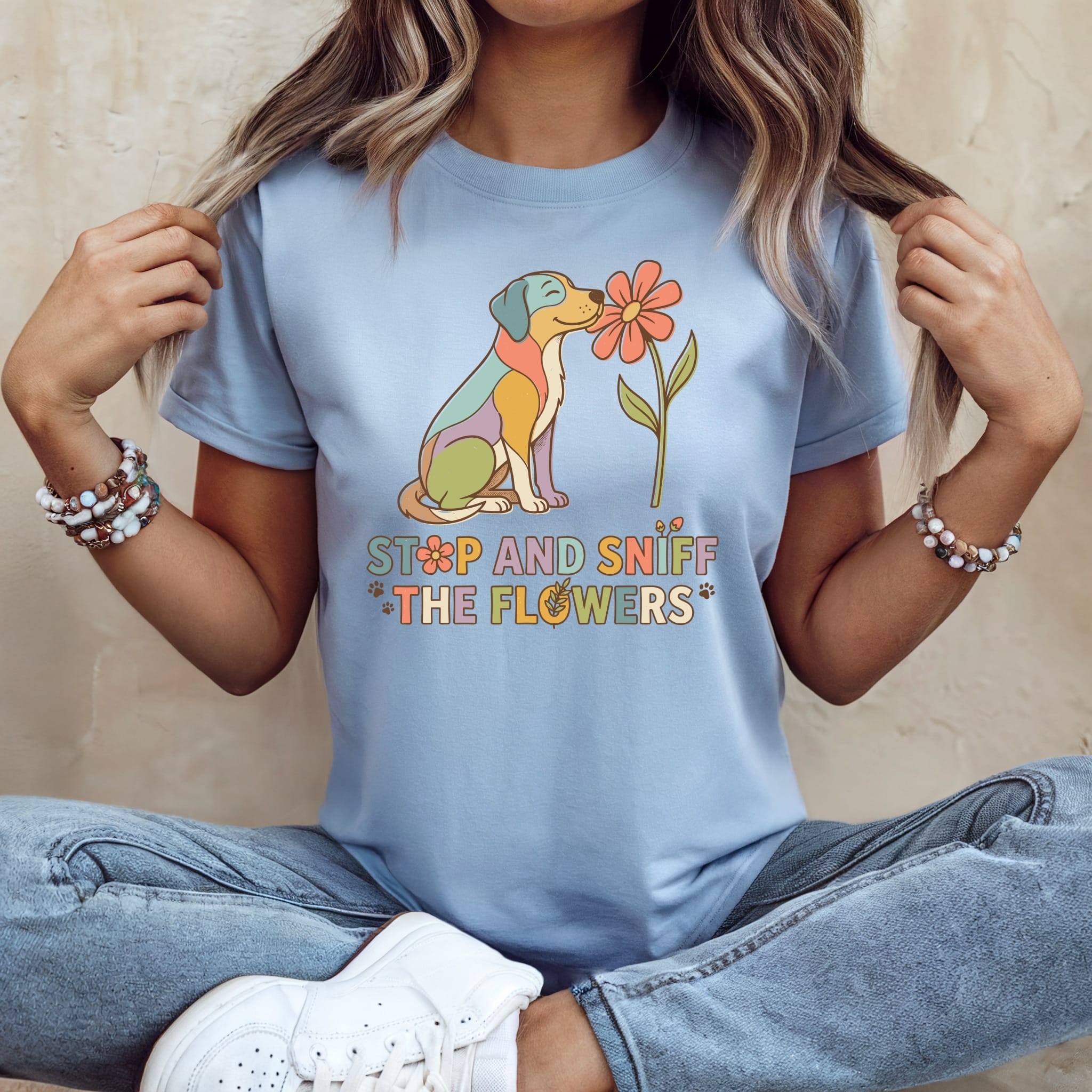 Light blue t-shirt with a colorful dog sniffing a flower and text.