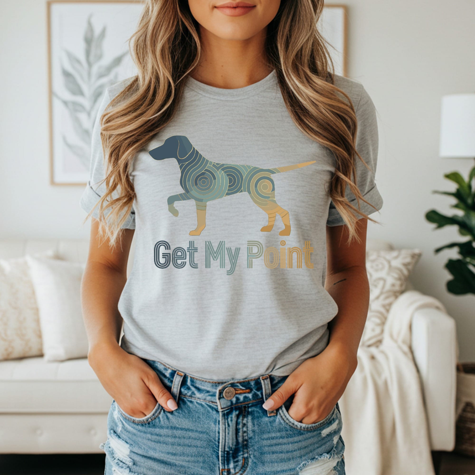 Woman in a grey t-shirt with a colorful abstract dog and "Get My Point" text.