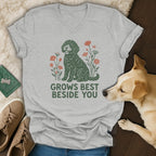 A light gray v-neck t-shirt featuring a green doodle graphic, flowers, and the text GROWS BEST BESIDE YOU.