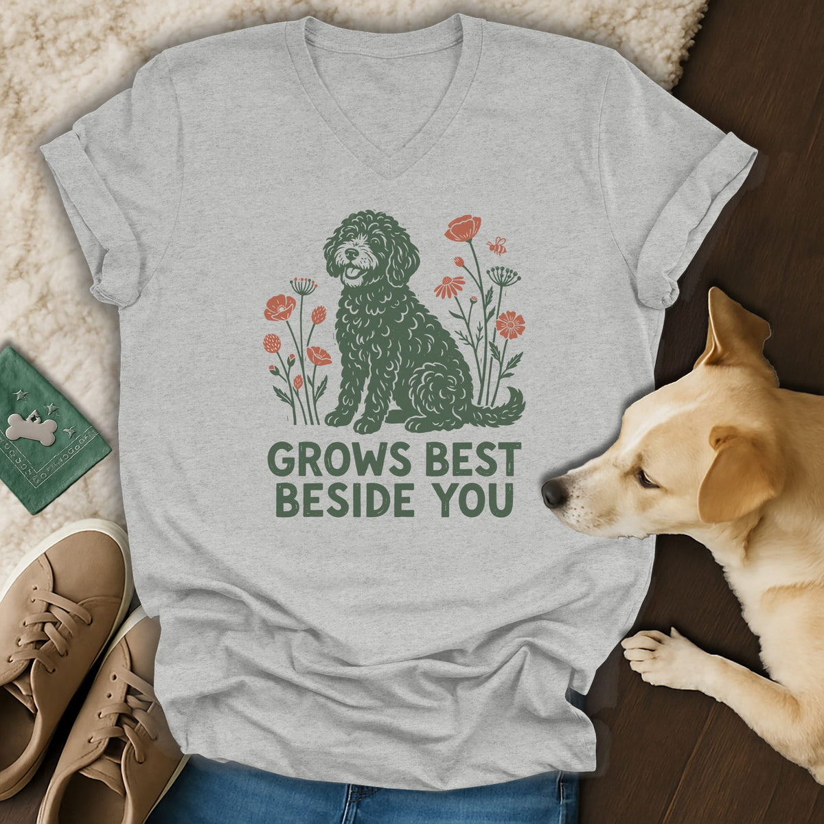 A light gray v-neck t-shirt featuring a green doodle graphic, flowers, and the text GROWS BEST BESIDE YOU.