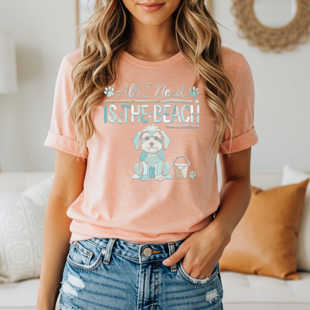 Peach t-shirt with graphic of dog, bucket, and text "All I Need Is The Beach".