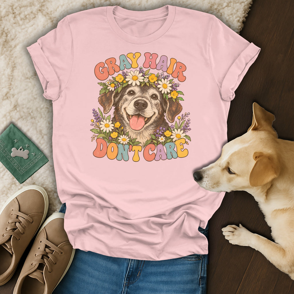 A pink t-shirt with a graphic of an elderly dog wearing a floral crown and the text Gray Hair Don't Care.