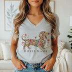 A woman wears a grey V-neck t-shirt featuring a floral dachshund graphic and the text DOXIE MAMA.