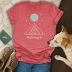 Red t-shirt with white line art of a dog in a tent under stars.