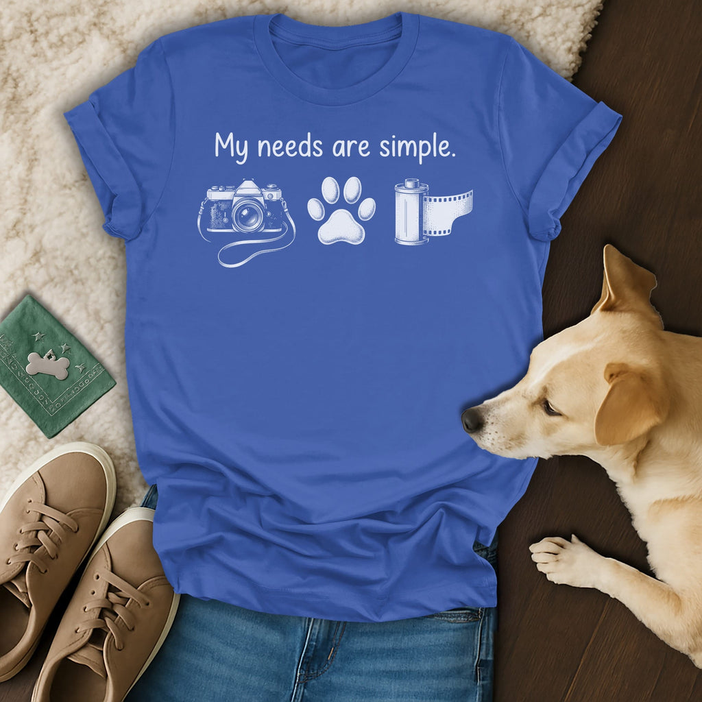 Blue t-shirt with "My needs are simple." and icons of a camera, paw print, and film.