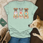 Light green t-shirt featuring three dogs with potted flowers and a light brown dog in foreground.