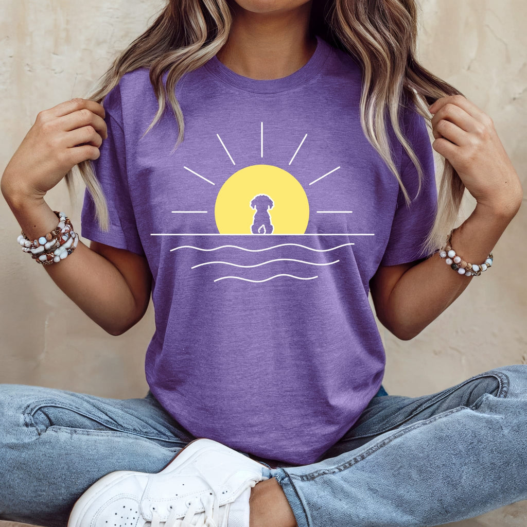 Purple t-shirt with a stylized sun, dog silhouette, and waves.