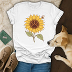 A white t-shirt featuring a sunflower graphic with a dog paw print center and a small flying bee.