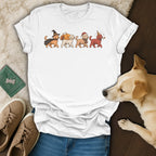 White t-shirt with four dogs in costumes: witch, turkey, Santa, and party hat.