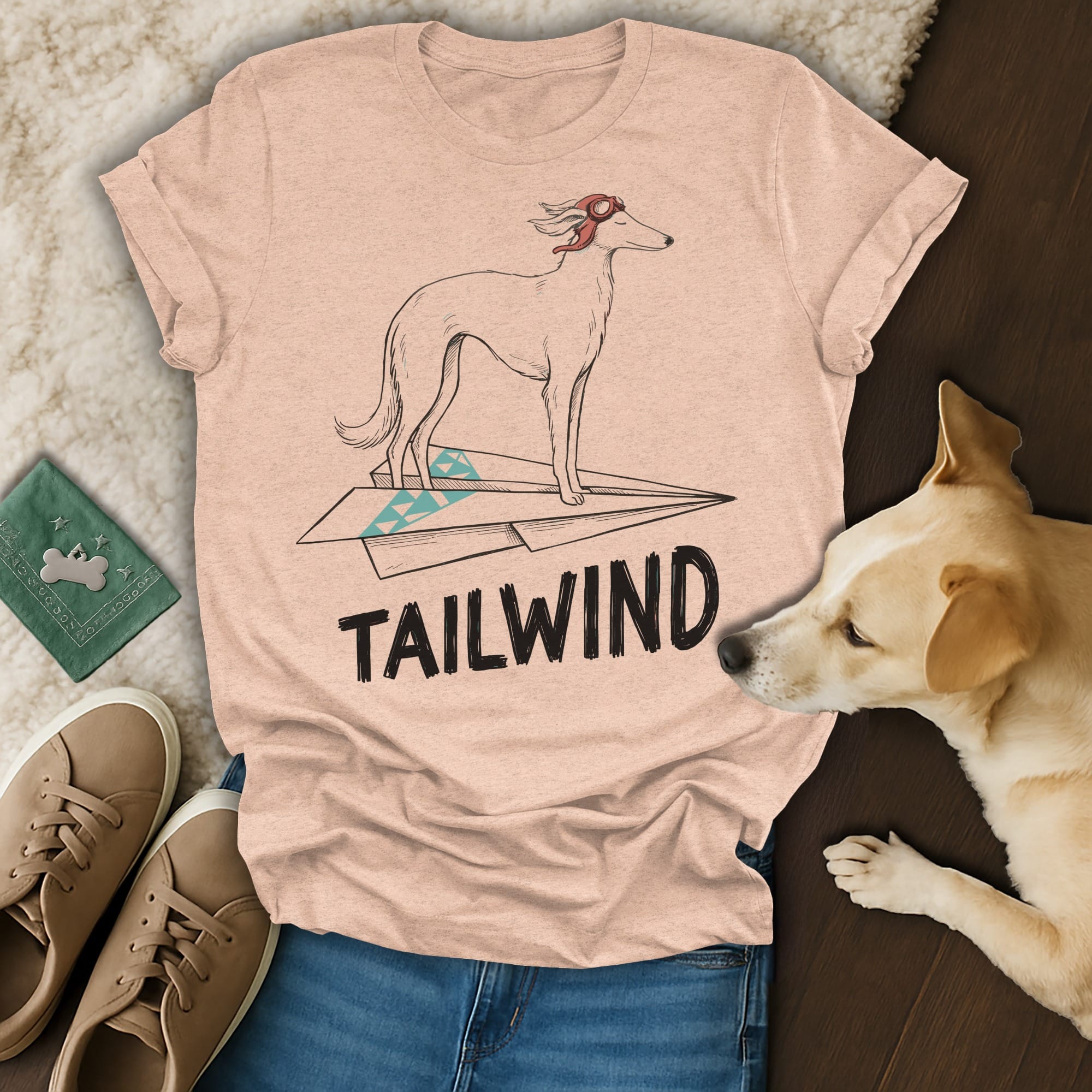 Light pink t-shirt with a dog on a paper airplane and "TAILWIND" text.