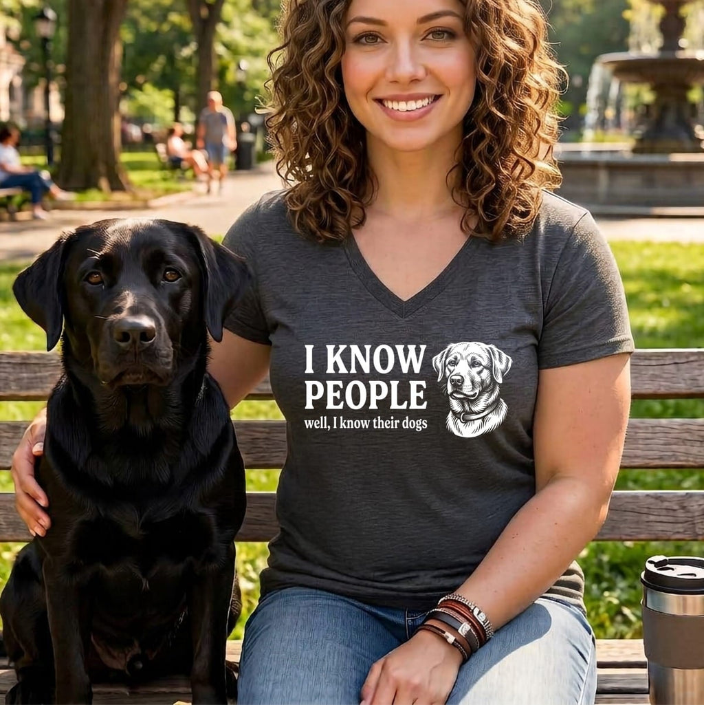 Woman with black lab wearing a t-shirt with "I know people well, I know their dogs" text.