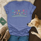 Blue t-shirt with colorful floral paw prints and bone accents.