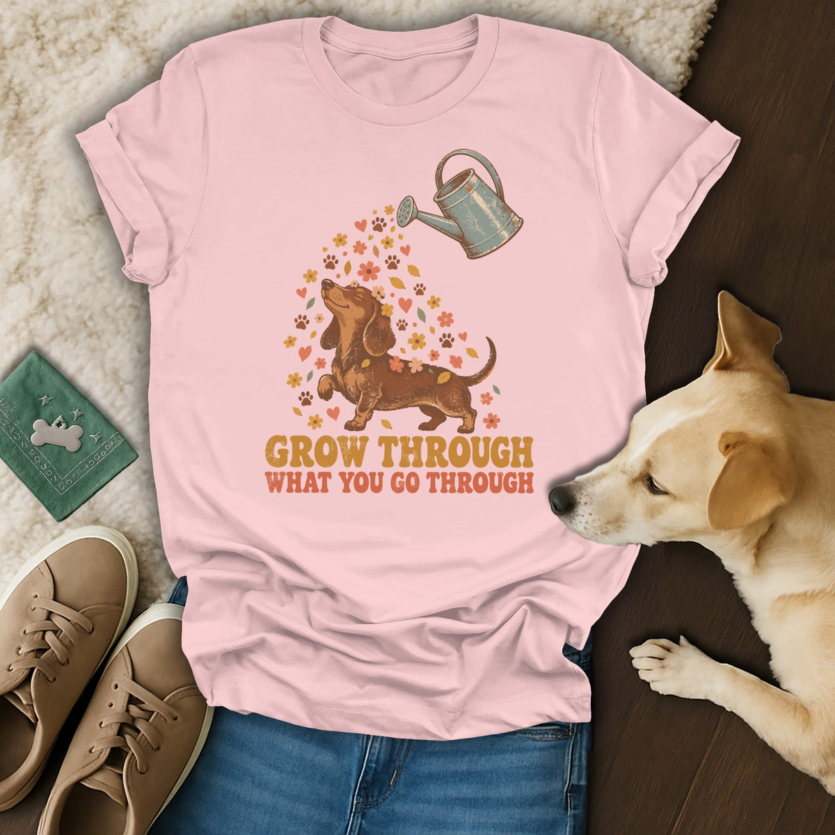 A light pink t-shirt features a dachshund graphic, a watering can, flowers, and the text Grow Through What You Go Through.