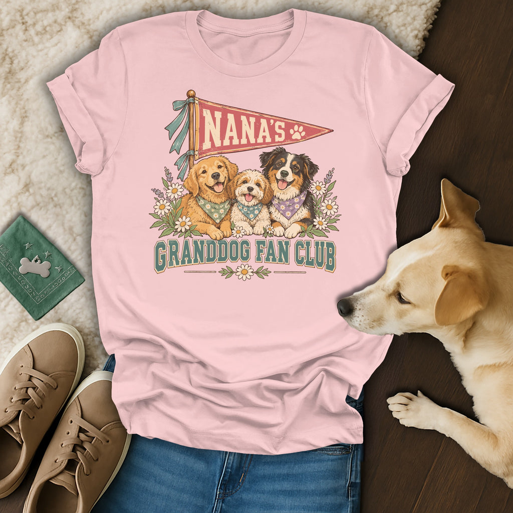 A light pink t-shirt featuring a graphic of three dogs and text reading Nana's Granddog Fan Club.