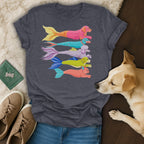 Dark t-shirt with five colorful dog-mermaid illustrations stacked vertically.