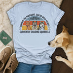 Light blue t-shirt with graphic of three dogs and text about pharaohs, vikings, and squirrels.