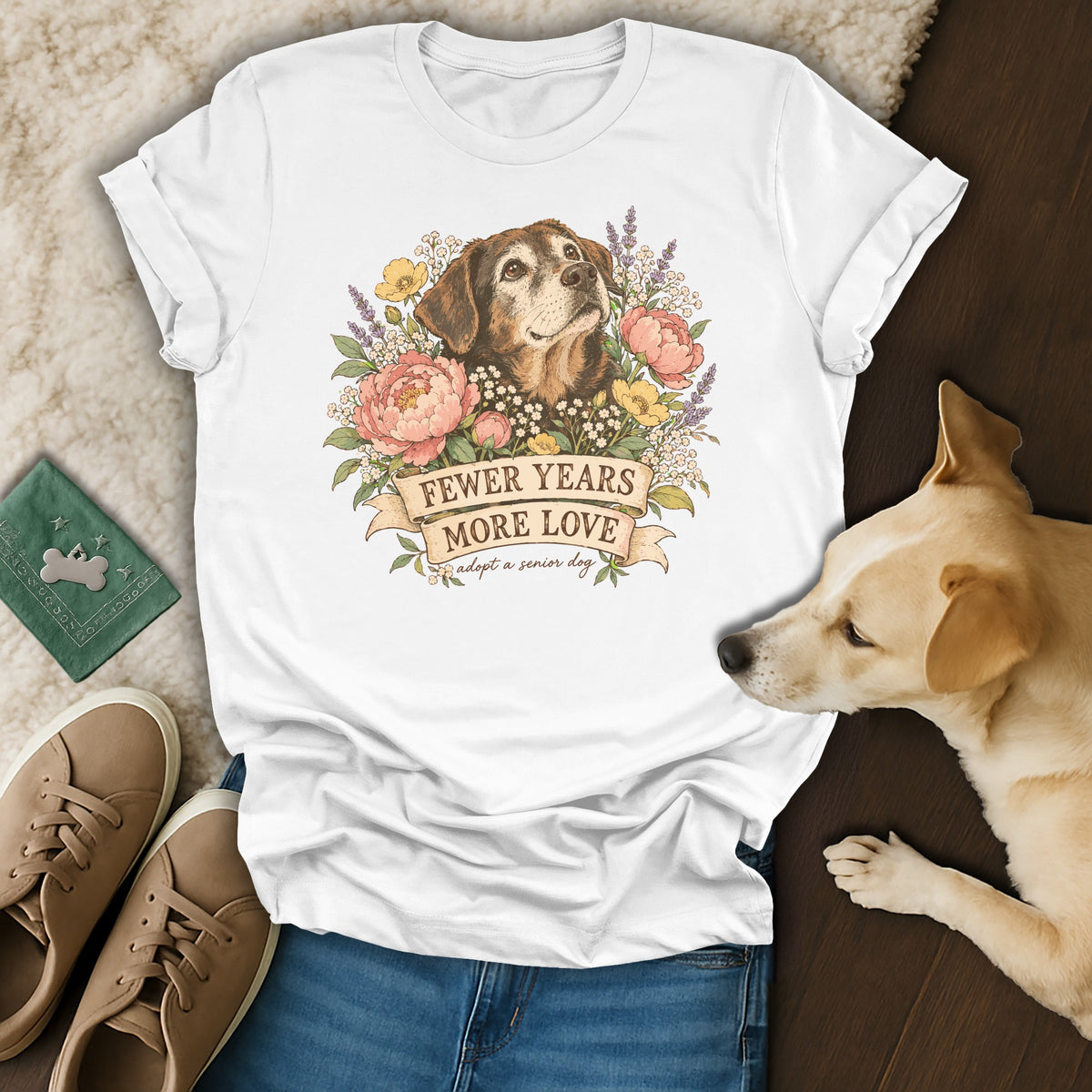 A white t-shirt featuring a graphic of a brown senior dog surrounded by flowers and text reading Fewer Years More Love.