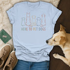 Light blue t-shirt with colorful outlined dogs and text "HERE TO PET DOGS".