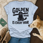 Light blue t-shirt with "GOLDEN HOUR IS EVERY HOUR" and a dog holding a stick.