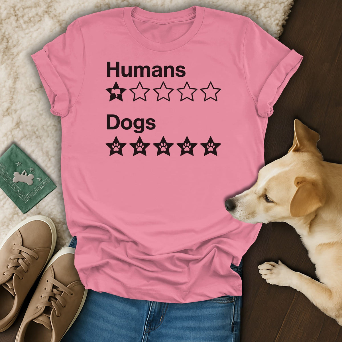 Pink t-shirt with black text "Humans" and one thumb-down star, and "Dogs" with five paw print stars.