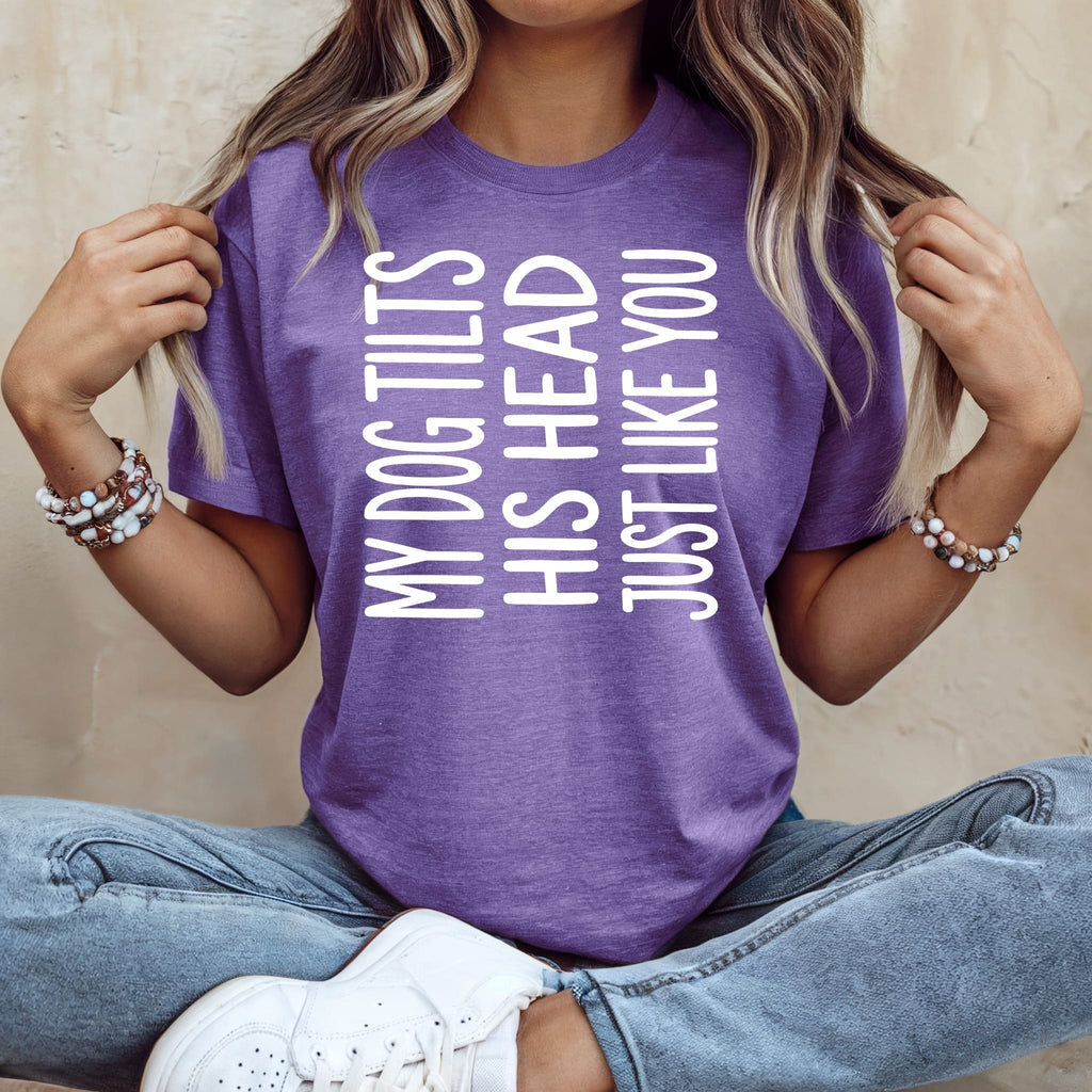 Purple t-shirt with white text reading "My dog tilts his head just like you".