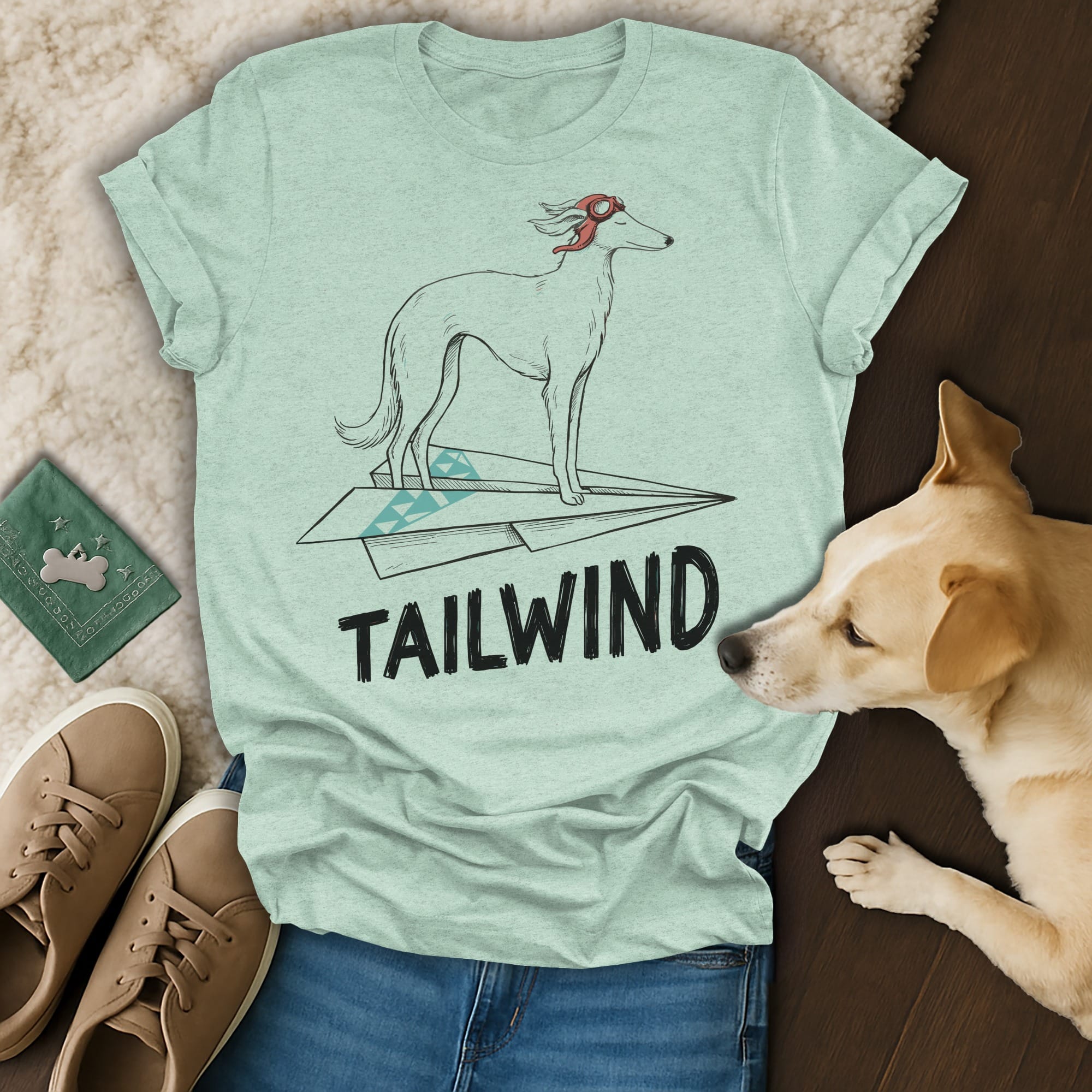 Greyhound dog wearing goggles on a paper airplane, with "TAILWIND" text.