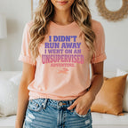 Peach t-shirt with "I didn't run away I went on an adventure" text and a dog icon.