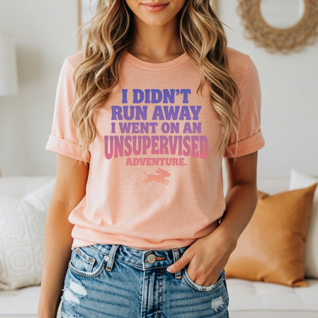 Peach t-shirt with "I didn't run away I went on an adventure" text and a dog icon.