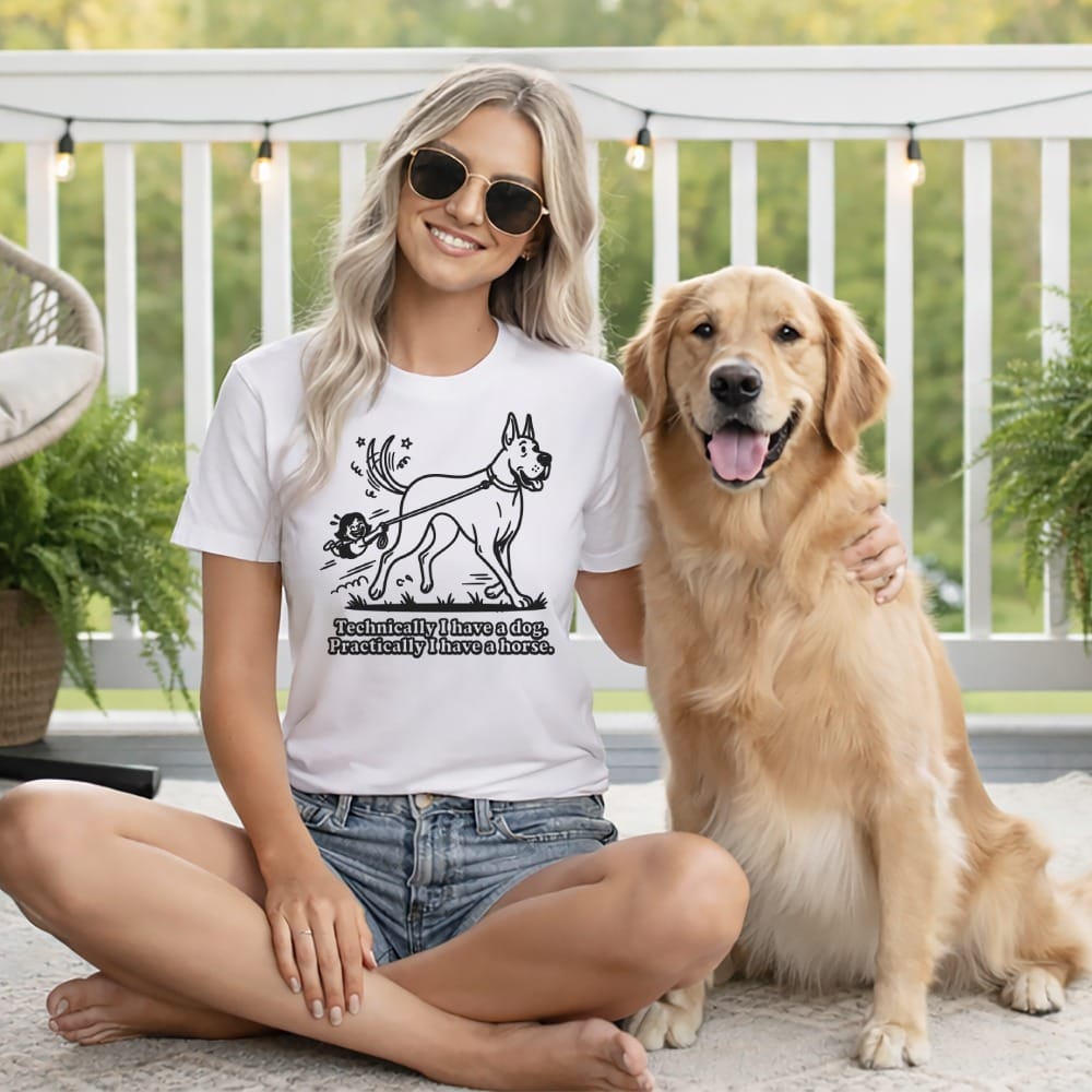 Woman in t-shirt with dog graphic and text, sitting with golden retriever.