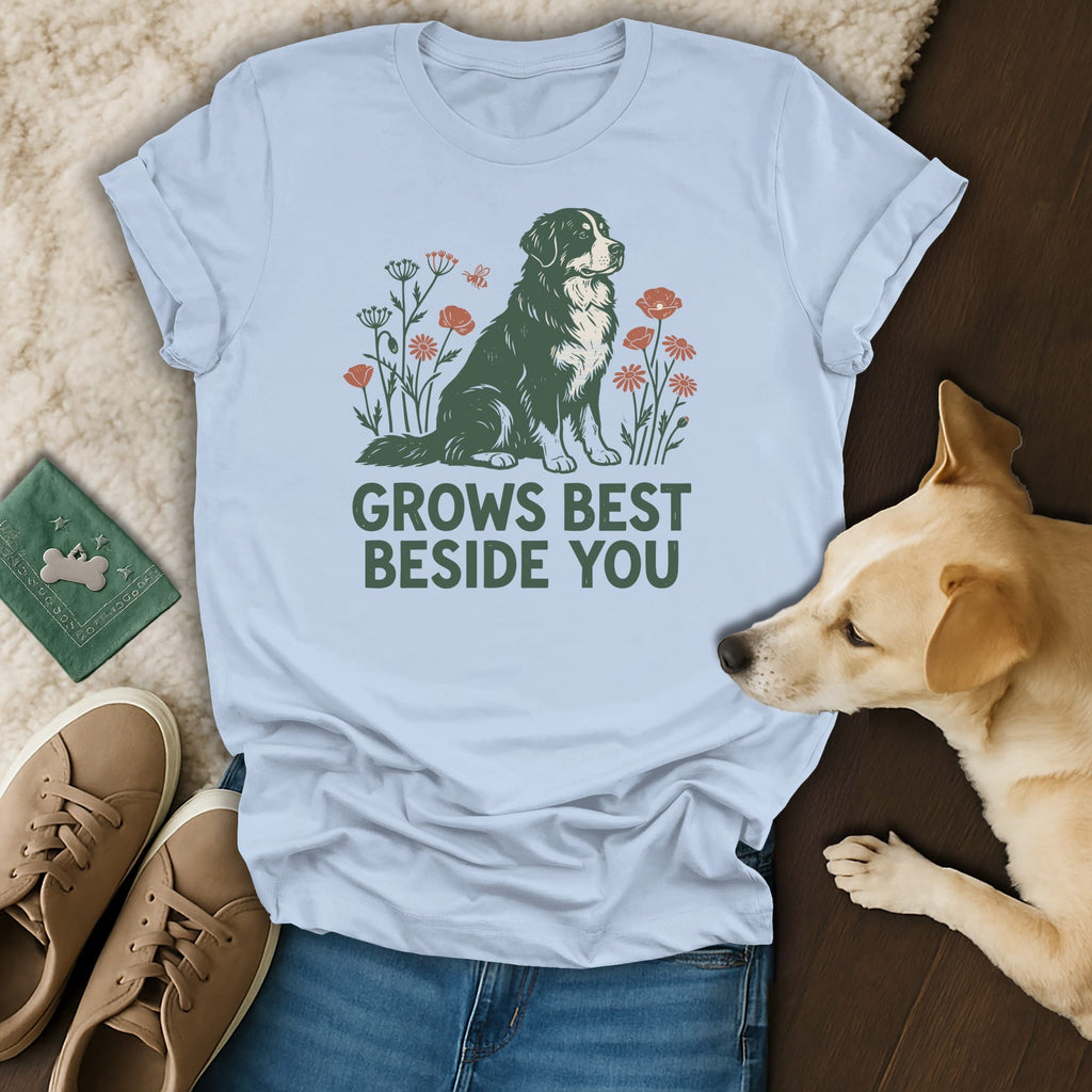 Light blue t-shirt featuring a graphic of a dog surrounded by flowers and the text GROWS BEST BESIDE YOU.