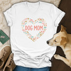 White v-neck shirt with "DOG MOM" in coral text surrounded by dog icons.