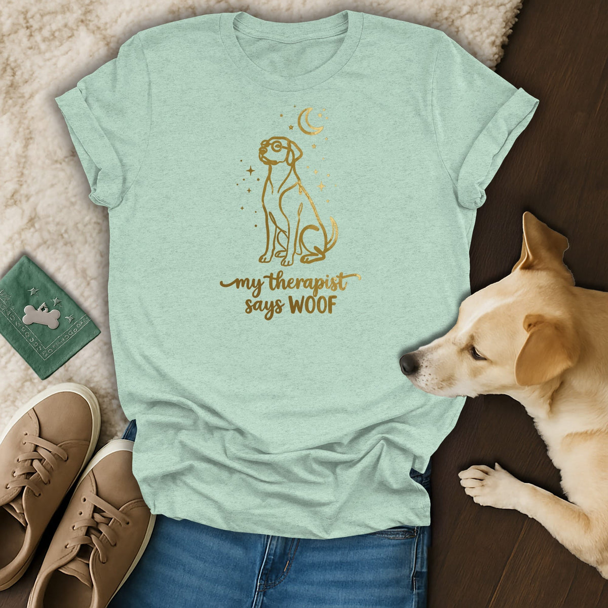Light teal t-shirt with gold line art of a dog wearing glasses, moon, and stars, and text "my therapist says WOOF".