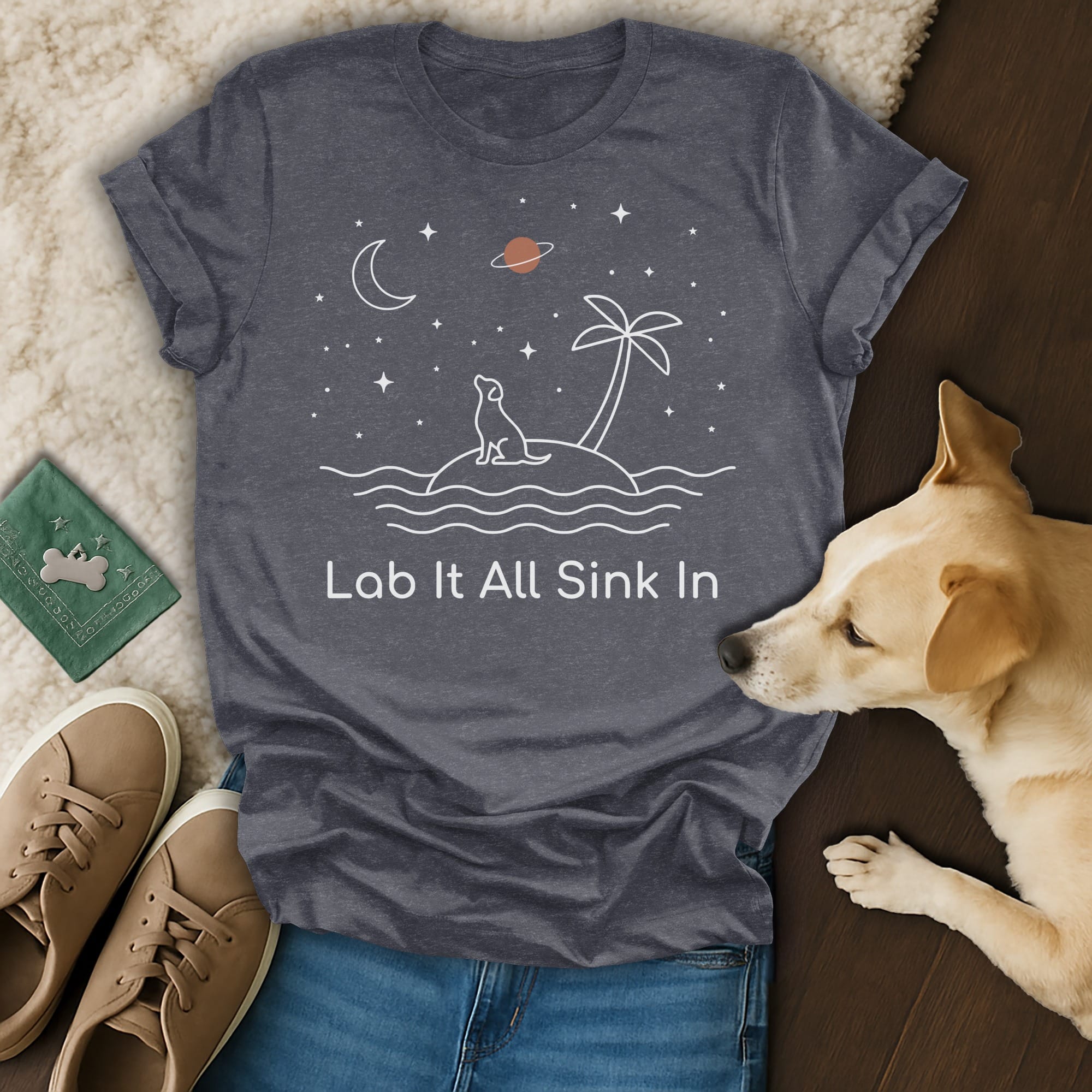 Dark grey t-shirt with white line art of a dog on an island under a starry sky.