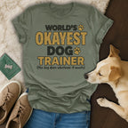 Olive green t-shirt with "World's Okayest Dog Trainer" text and a dog.