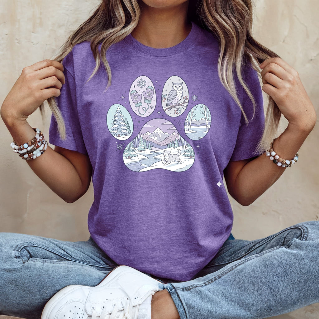 Purple t-shirt with a paw print design featuring a winter scene.