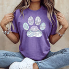 Purple t-shirt with a paw print design featuring a winter scene.