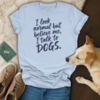 Light blue t-shirt with "I look normal but believe me, I talk to DOGS." text.
