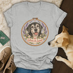Heather gray v-neck t-shirt featuring an embroidered hoop graphic of a black dog surrounded by flowers and the text Silver & Sweet.