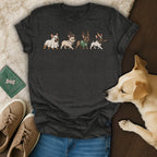 Four cartoon French Bulldogs in holiday costumes on a dark grey t-shirt.