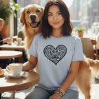 Woman with Golden Retriever at cafe wearing t-shirt with heart and paw print design.