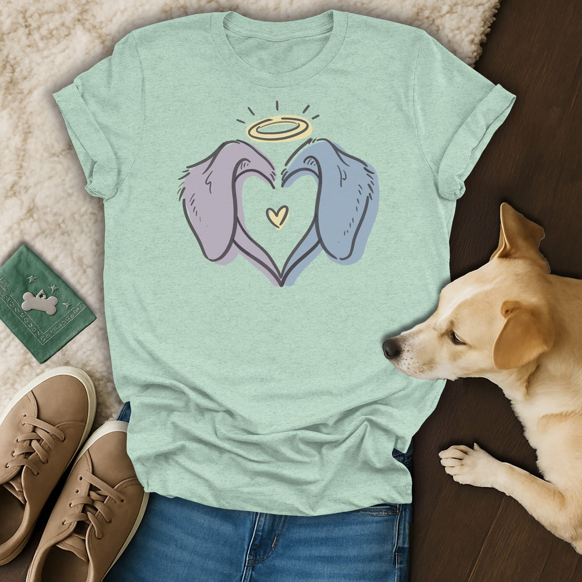Light green t-shirt with a drawing of two dog ears forming a heart, a halo, and a small heart.