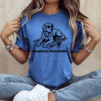 T-shirt with black graphic of dog in sunglasses on beach towel with drink.