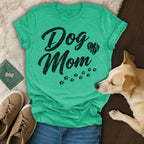 Green t-shirt with "Dog Mom" text and paw prints, with dog and shoes.